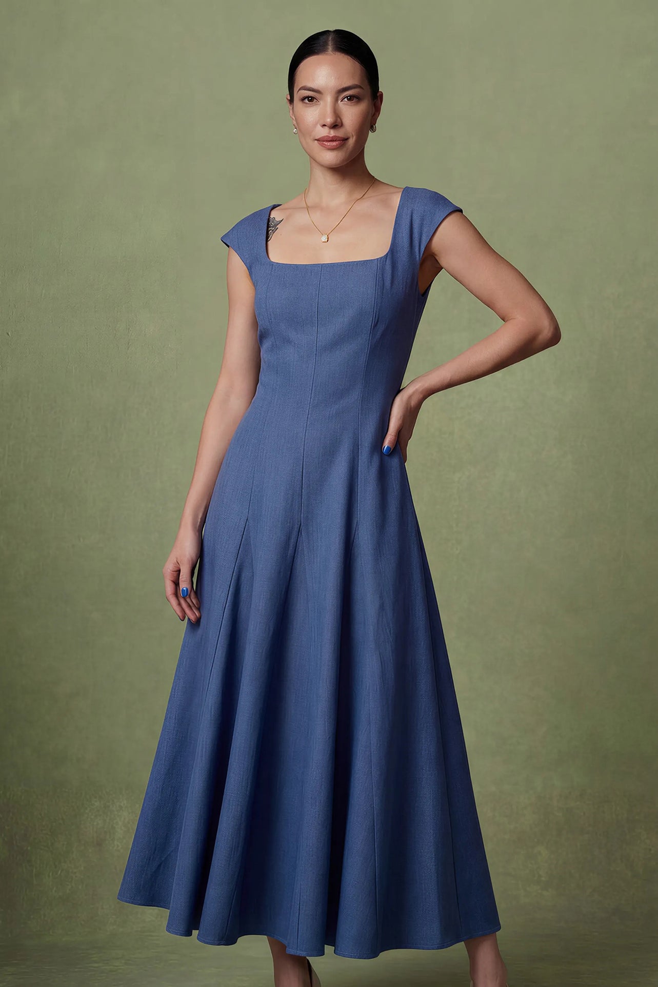 A professional woman modeling an elegant mid-blue midi dress featuring a classic square neckline, cap sleeves, and a flattering A-line flare skirt, perfect for both business and social occasions.