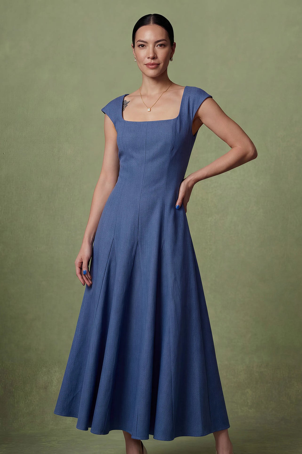 A professional woman modeling an elegant mid-blue midi dress featuring a classic square neckline, cap sleeves, and a flattering A-line flare skirt, perfect for both business and social occasions.