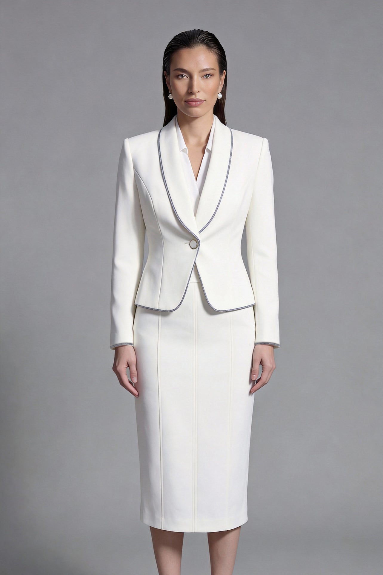 Two elegant professional women modeling high-end monochrome executive suits, one in a black blazer with white piping and wide-leg trousers, the other in a white blazer with dark trim and a matching pencil skirt.