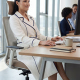 An elegant professional woman wearing a sophisticated white double-breasted coat dress featuring sharp navy blue contrast piping and a matching waist belt for a tailored executive look