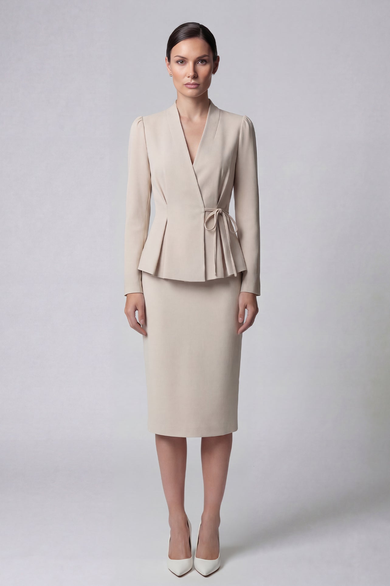 A professional woman wearing a sophisticated navy blue blazer, featuring an elegant pussy-bow neck tie, a flattering tie-waist wrap design, and subtle puff sleeves for a polished executive look.