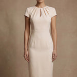 A professional woman modeling a sophisticated blush pink sheath dress, featuring a unique gathered neckline with keyhole detail and a tailored slim fit for a timeless executive look.