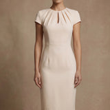 A professional woman modeling a sophisticated blush pink sheath dress, featuring a unique gathered neckline with keyhole detail and a tailored slim fit for a timeless executive look.
