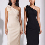 A style comparison of two elegant one-shoulder midi dresses; the left showcasing a sophisticated beige tailored sheath dress with a large tie-bow shoulder strap, and the right featuring the same design in timeless minimalist black.