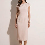 A professional woman modeling an elegant pale pink sheath dress, featuring a sophisticated crew neckline, cap sleeves, and a tailored slim fit with princess seams for a timeless executive look.