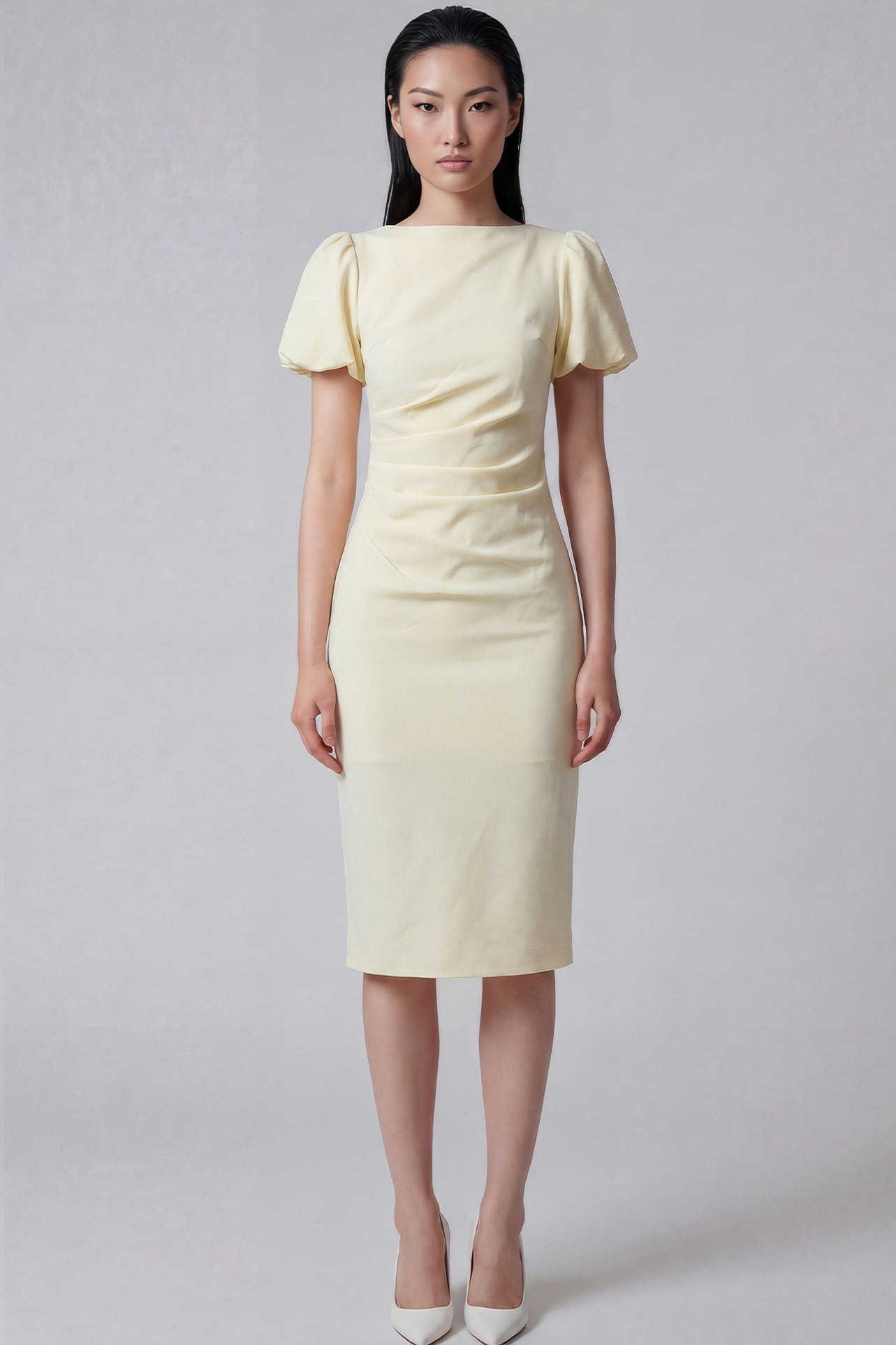 A professional woman wearing a sophisticated pale yellow short-sleeve midi dress, featuring elegant puff sleeves and a slimming ruched waistline for a polished and fresh summer office look.