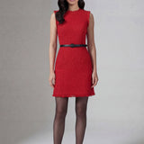 A professional woman wearing a sophisticated vibrant red tweed sleeveless mini dress, featuring a classic round neck, elegant frayed edges, and a slimming black waist belt for a chic holiday or office look.