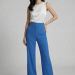A professional woman wearing sophisticated royal blue high-waisted wide-leg trousers, featuring a tailored loose-fit silhouette for a modern and vibrant executive office look.