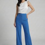 A professional woman wearing sophisticated royal blue high-waisted wide-leg trousers, featuring a tailored loose-fit silhouette for a modern and vibrant executive office look.