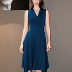 A professional woman modeling an elegant royal blue sleeveless V-neck dress, featuring a tailored fit-and-flare silhouette and a flowing midi A-line skirt for a sophisticated office or social look.