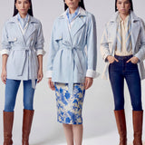 A professional woman wearing an elegant light blue short trench coat with a waist-tie belt and white sleeve cuffs, perfect for a smart casual spring office look.