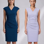 A style comparison of two elegant professional midi dresses with short cap sleeves; the left showcasing a sophisticated teal blue tailored sheath dress with a V-neckline and refined side ruching, and the right featuring the same slimming draping design in a soft pastel lavender lilac color.
