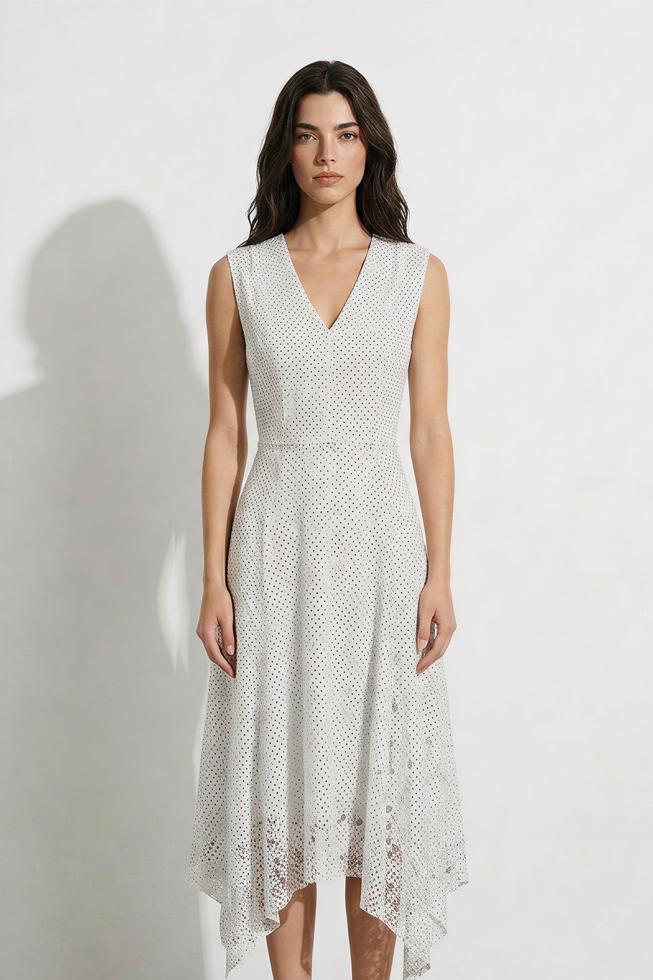 A professional woman modeling an elegant white lace sleeveless dress, featuring a sophisticated V-neckline, a tailored fit-and-flare silhouette, and an intricate hollow-out eyelet texture with a delicate lace trim hem.