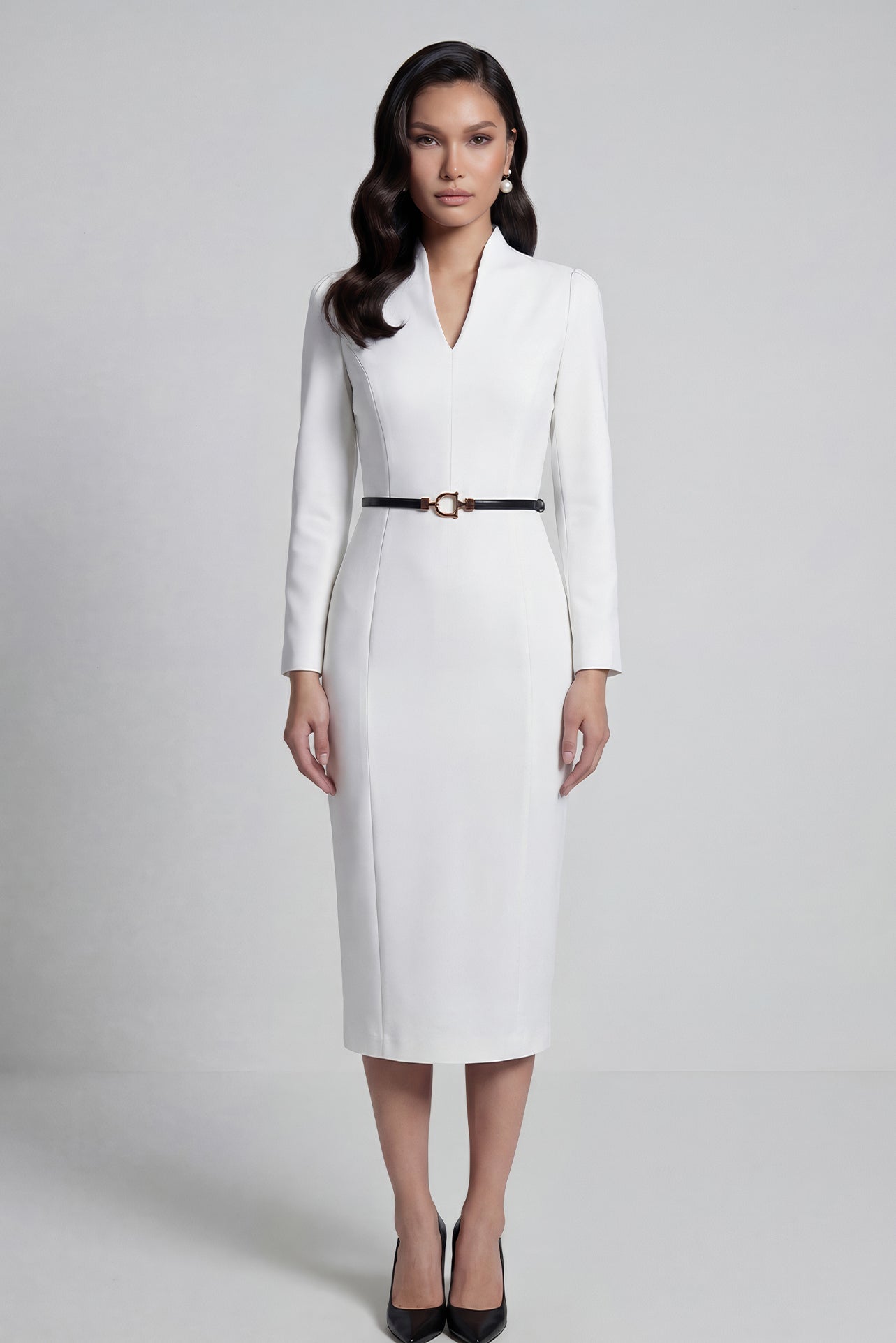 A professional woman wearing a sophisticated solid white long-sleeve sheath dress, featuring an elegant V-neckline and a slim black belt with a gold buckle for a polished executive office look.