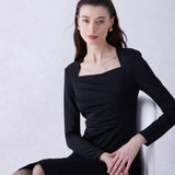 A professional woman wearing a sophisticated deep magenta long-sleeve pencil dress, featuring a unique square neckline and elegant ruched detailing at the waist for a flattering, slim-fit executive look.