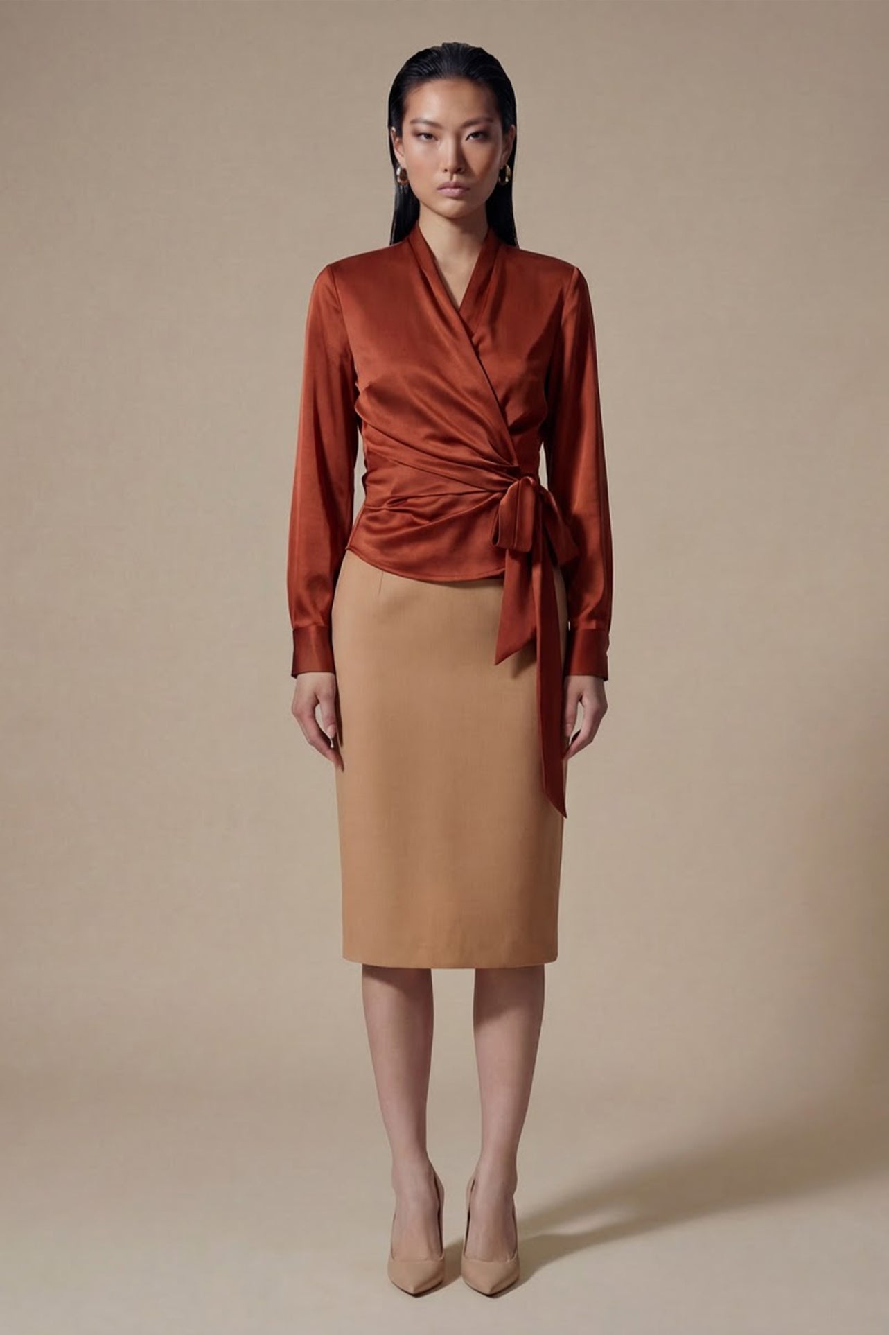 A professional woman wearing a high-end white silk wrap blouse with a side-tie detail, paired with a tailored black high-waisted pencil skirt for a sophisticated executive office look.