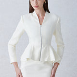 A professional woman wearing a sophisticated cream tweed skirt suit, featuring a tailored jacket with a modern front zipper and an elegant stand collar for a polished executive office look.