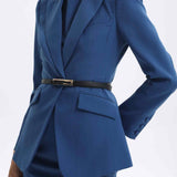 A professional woman wearing a sophisticated royal blue tailored skirt suit, featuring a slim-fit single-button blazer with structured shoulders and a matching midi pencil skirt for a powerful executive office look.