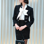 A chic woman wearing a luxurious black sparkle tweed tailored jacket featuring an authentic stand cheongsam collar, elegant horizontal pearl bar closures, and a flattering hourglass waistline.
