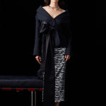 A woman wearing a glamorous high-waisted pencil skirt featuring shimmering silver and black sequins in a stylish zebra print, ideal for an elegant evening party or a night out.