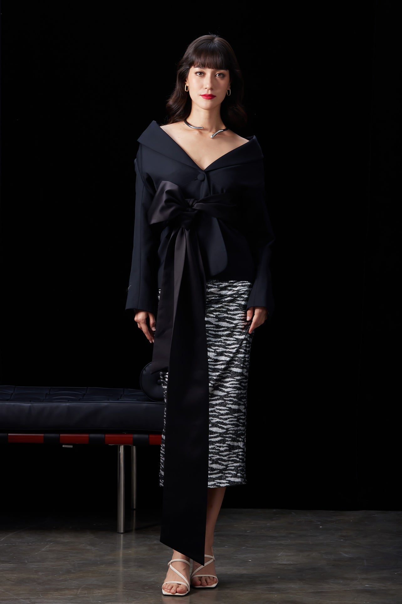 A woman wearing a glamorous high-waisted pencil skirt featuring shimmering silver and black sequins in a stylish zebra print, ideal for an elegant evening party or a night out.