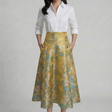 A professional woman wearing a sophisticated high-waisted A-line skirt, featuring a luxurious gold and teal wave pattern jacquard fabric and elegant full-skirt volume for a formal event.