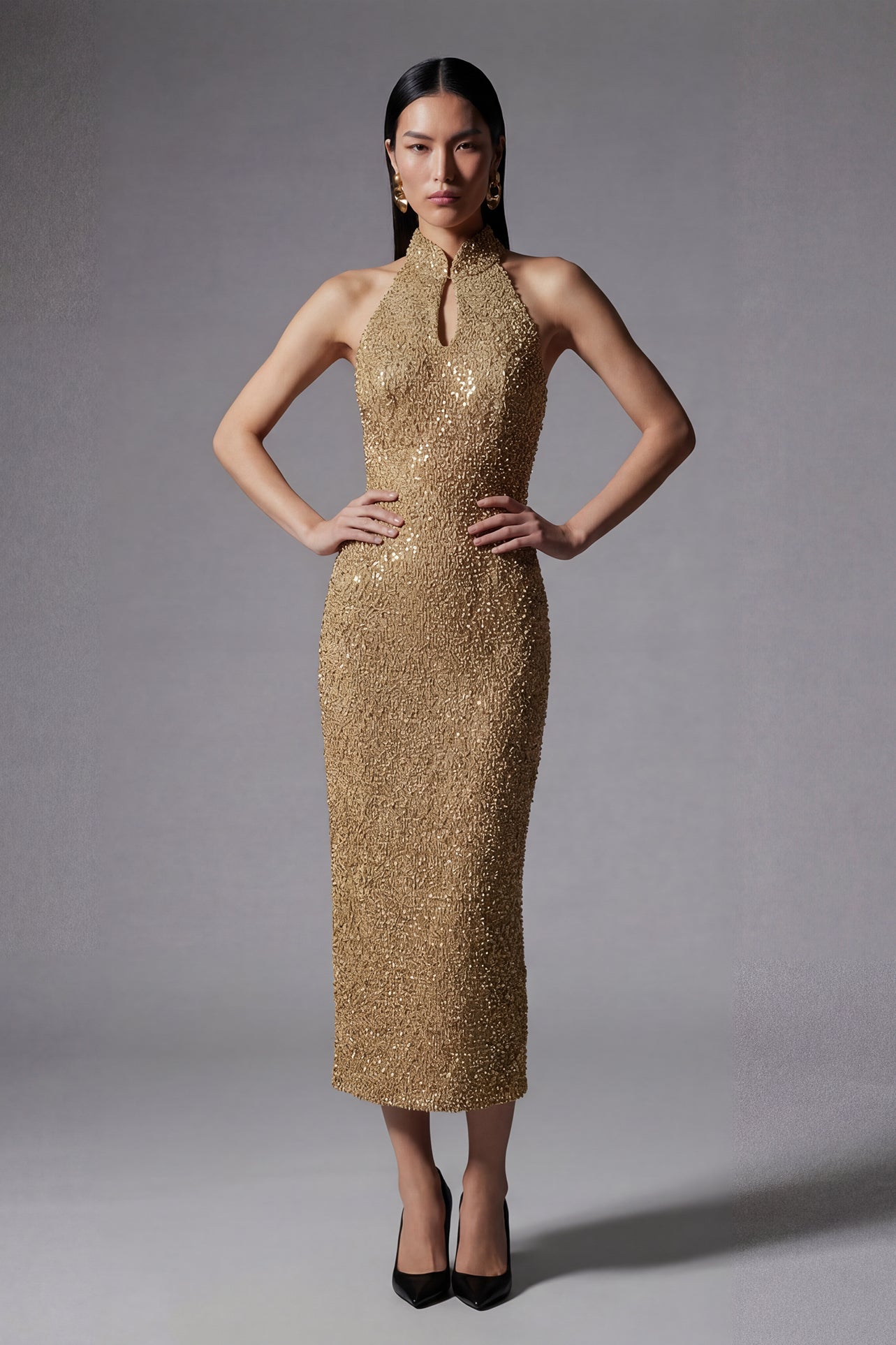 A stunning professional model wearing a luxurious gold sequined halter neck evening gown, featuring a sophisticated keyhole neckline and a slim-fit silhouette for a formal gala look.