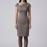 A professional woman wearing a sophisticated taupe grey sheath dress, featuring a chic asymmetric neckline, cap sleeves, and a tailored slim-fit silhouette for an elegant office look.