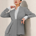 A beautiful professional model wearing an elegant grey pinstripe collarless blazer featuring a distinctive tie-front knot at the waist, styled with a crisp white collared shirt underneath for a modern corporate chic look.