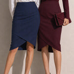 A style comparison of two elegant women's high-waisted pencil skirts featuring an overlapping crossover tulip hemline; shown on the left in deep navy blue paired with a white shirt, and on the right in rich burgundy wine paired with a matching long-sleeve top and suede clutch.