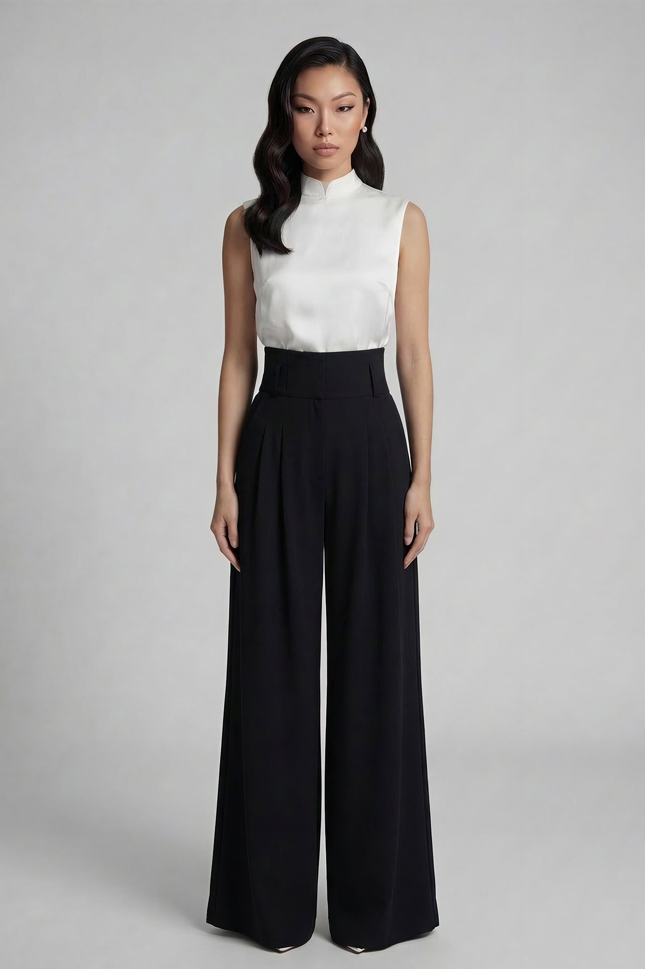 A professional woman wearing sophisticated black high-waisted wide-leg trousers, featuring a flattering high-rise fit and a flowing full-length silhouette for an elegant office look.