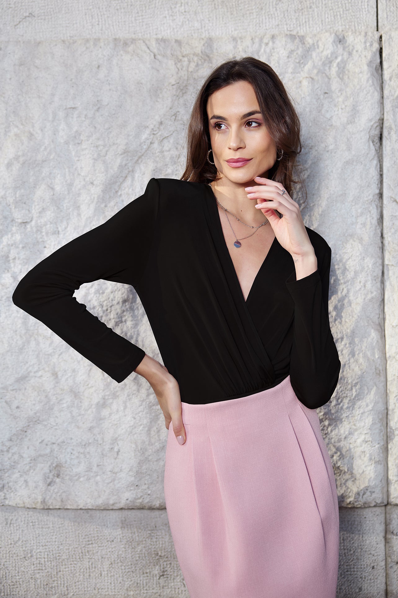 A professional woman wearing sophisticated high-waisted wide-leg pinstripe trousers in charcoal black, featuring a tailored slimming fit for a powerful executive office look.