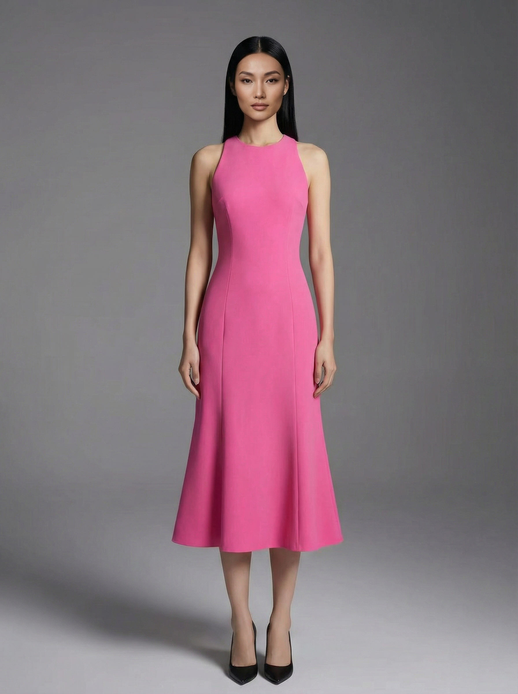 A professional woman wearing an elegant bright pink sleeveless midi dress, featuring a sophisticated round neckline and a feminine flared mermaid-style hem for a polished summer look.