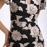 A professional woman wearing a modern black mini qipao dress, featuring elegant white floral embroidery, voluminous puff sleeves, and a chic keyhole neckline with a mandarin collar for a stylish party look.