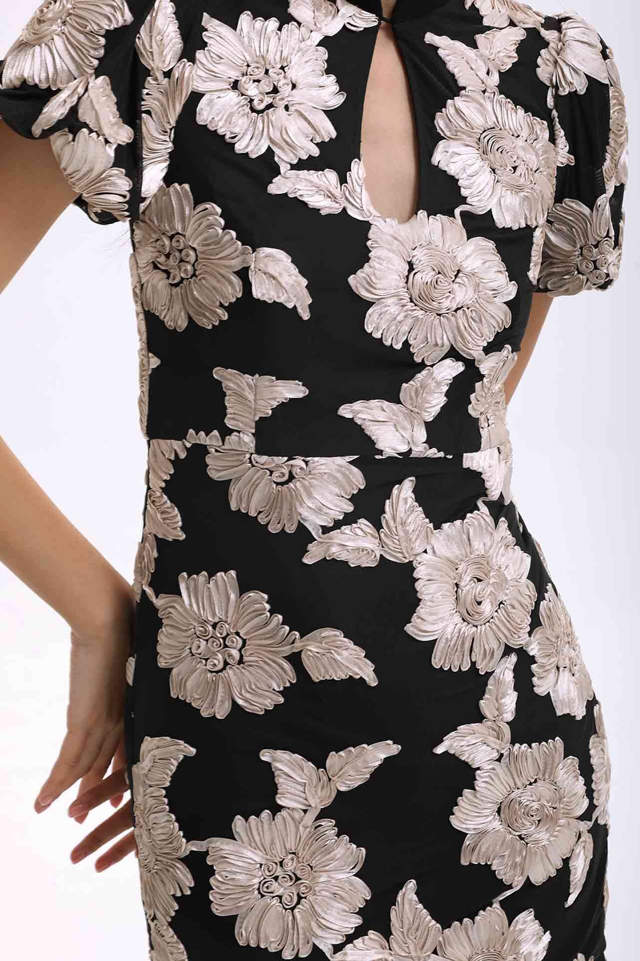 A professional woman wearing a modern black mini qipao dress, featuring elegant white floral embroidery, voluminous puff sleeves, and a chic keyhole neckline with a mandarin collar for a stylish party look.