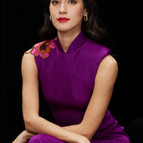 A professional woman wearing a stunning purple satin sleeveless dress, featuring a traditional mandarin collar and delicate floral embroidery on the shoulder for a modern oriental-inspired formal look.