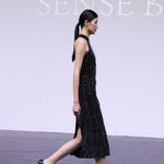 A stunning woman wearing a sophisticated black sequin halter midi dress, featuring a traditional mandarin collar and a shimmering bodycon silhouette, perfect for a modern oriental-inspired evening party look.