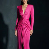A sophisticated woman wearing a vibrant magenta long-sleeve dress, featuring a plunging V-neckline and an elegant knot-front twist at the waist for a stunning evening gala look.