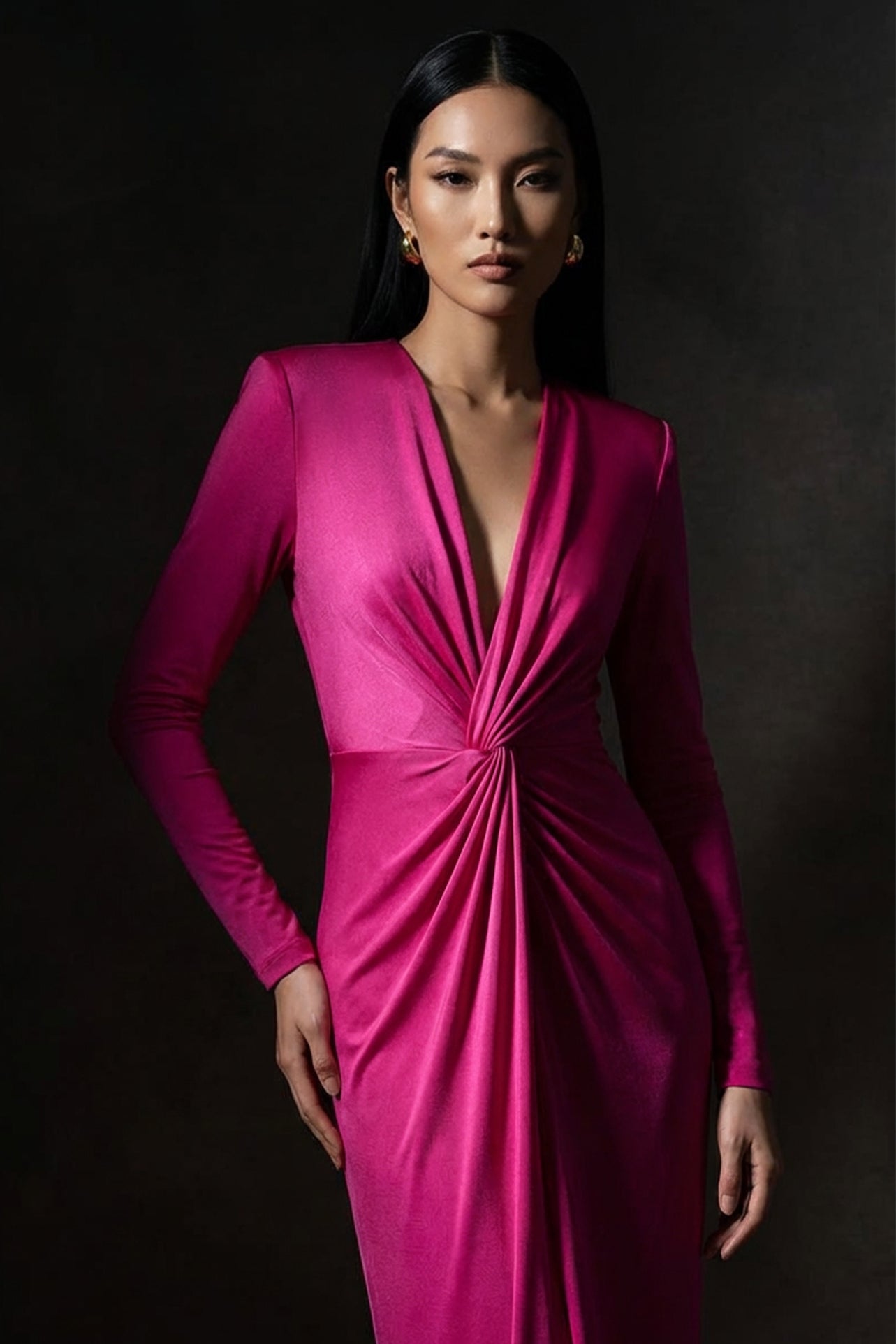 A sophisticated woman wearing a vibrant magenta long-sleeve dress, featuring a plunging V-neckline and an elegant knot-front twist at the waist for a stunning evening gala look.