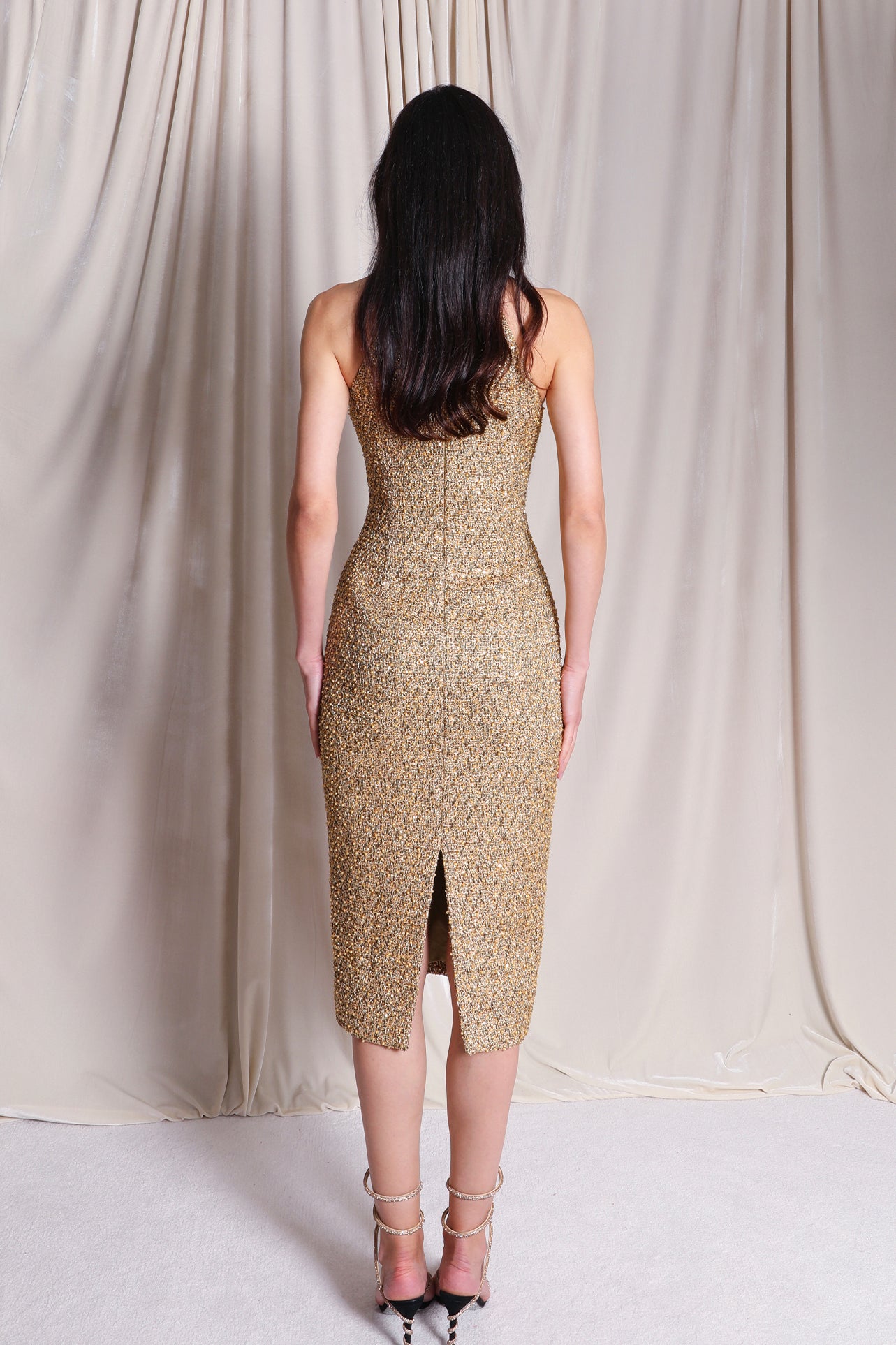 A stunning professional model wearing a luxurious gold sequined halter neck evening gown, featuring a sophisticated keyhole neckline and a slim-fit silhouette for a formal gala look.
