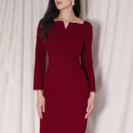 A professional woman wearing a sophisticated black long-sleeve midi dress, featuring a unique notched square neckline and a tailored slim-fit pencil silhouette for a polished executive office look.