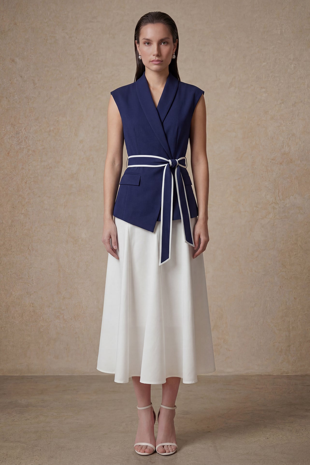 A comparison of two elegant professional looks: a navy blue pleated midi skirt and a crisp white flare skirt, both featuring sophisticated contrast-piped bow belts for a polished executive appearance.