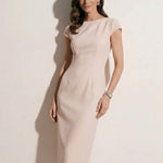 A professional woman modeling an elegant pale pink sheath dress, featuring a sophisticated crew neckline, cap sleeves, and a tailored slim fit with princess seams for a timeless executive look.