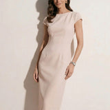 A professional woman modeling an elegant pale pink sheath dress, featuring a sophisticated crew neckline, cap sleeves, and a tailored slim fit with princess seams for a timeless executive look.