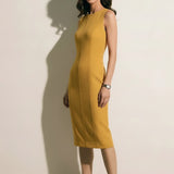 A professional woman modeling an elegant mustard yellow sleeveless sheath dress, featuring a sophisticated crew neckline and a tailored slim fit with princess seams for a polished executive look.