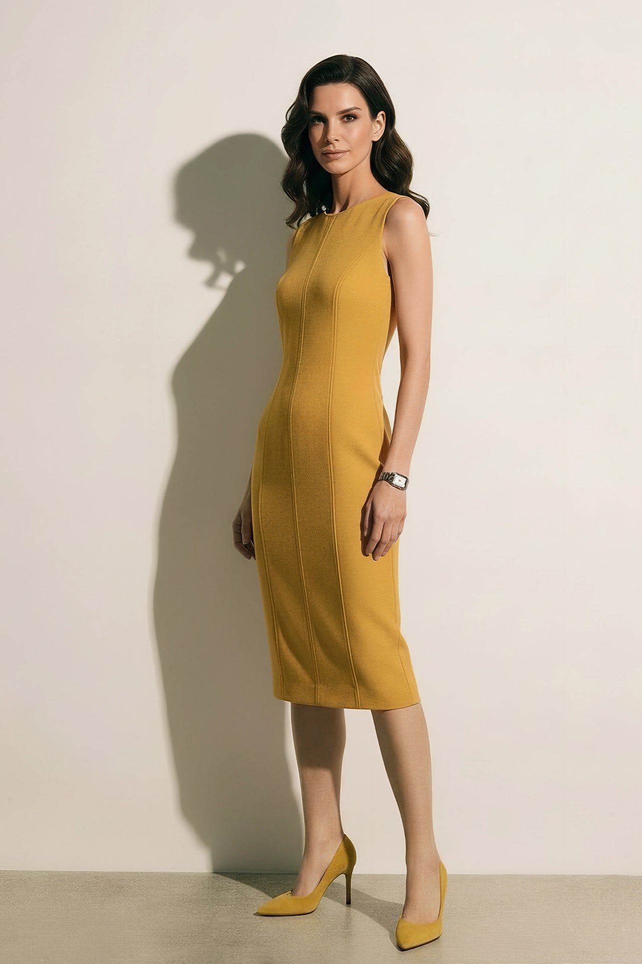A professional woman modeling an elegant mustard yellow sleeveless sheath dress, featuring a sophisticated crew neckline and a tailored slim fit with princess seams for a polished executive look.