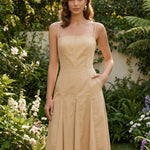 Two professional women modeling elegant square-neck spaghetti strap maxi dresses in khaki and mustard yellow, featuring a pleated A-line silhouette and side pockets for a sophisticated summer look.