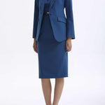 A professional woman wearing a sophisticated royal blue tailored skirt suit, featuring a slim-fit single-button blazer with structured shoulders and a matching midi pencil skirt for a powerful executive office look.