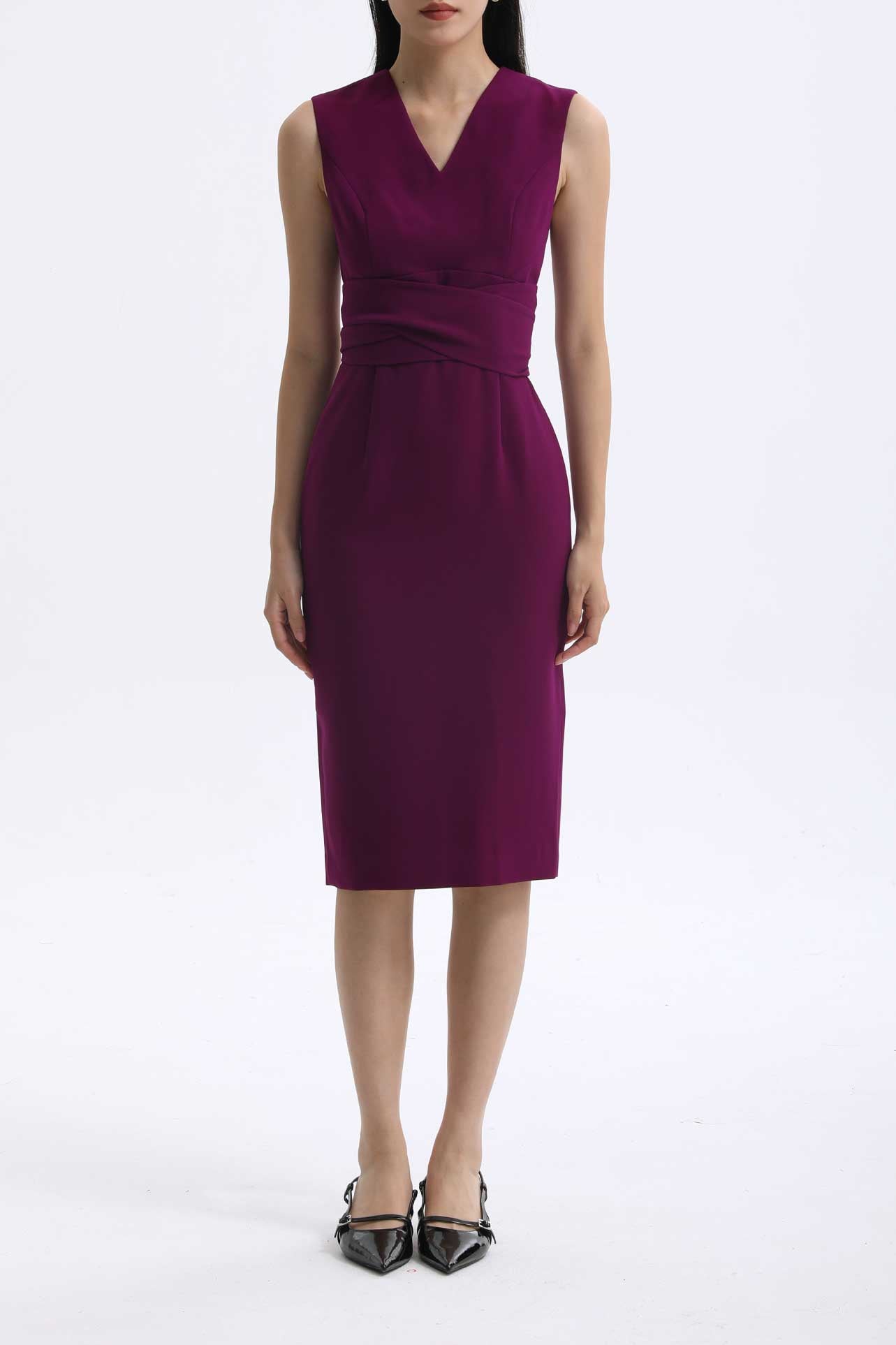 A professional woman wearing a sophisticated magenta v-neck sleeveless midi dress, featuring a tailored slim-fit pencil silhouette for a polished executive office or cocktail look.