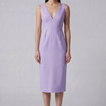 A professional woman showcasing two elegant sleeveless V-neck sheath dresses in classic black and soft lilac purple, featuring functional side pockets and a tailored fit for a polished office look.